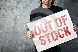 Out of Stock sign in hands of storage employee