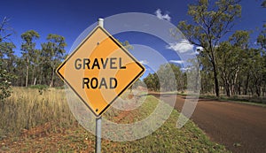 Outback Australian road with gravel warning sign