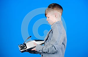 Outdated gadget. Retro and vintage. Yard sale. Retrospective study. Boy hold retro typewriter on blue background. What photo