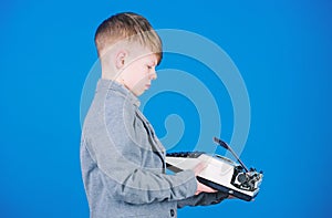 Outdated gadget. Retro and vintage. Yard sale. Retrospective study. Boy hold retro typewriter on blue background. What photo