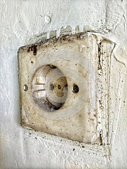 An outdated socket in the wall of the house