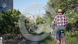 Outdoor activities, cute boy in sun hat with their loving grandmother and grandfather have fun and ride bicycles in