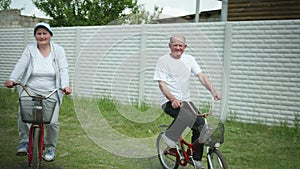 Outdoor activities, happy elderly man and woman enjoying cycling, an old joyful couple have fun while cycling