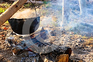 outdoor adventures concept. beaten cauldron on camp fire