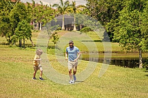 Outdoor adventures between father and son. Active father son playing football in summer. Father and child son teaming up