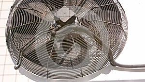 outdoor air conditioner condenser electrical fan spinning, decelerating and accelerating