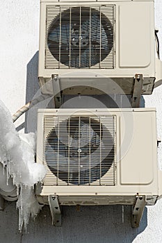An outdoor air conditioner unit consisting of two fans. A large industrial air conditioner on the wall of a store or enterprise.