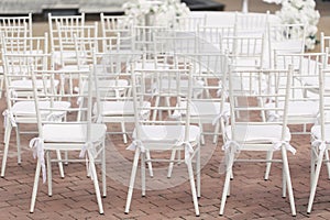 Outdoor area for wedding ceremonies with white chairs.
