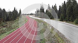 Outdoor athletics running track on sports base in mountains. Sport training base for athletes. Running treadmill with lanes. Sport