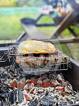 Outdoor barbecue. Meat and pita bread on a grill over hot coals