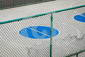 Outdoor basketball court middle circle - behind fence