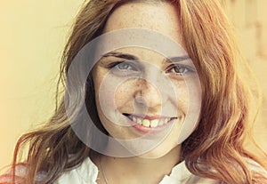 Outdoor beauty. Portrait of smiling young and happy woman with freckles.