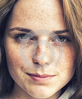 Outdoor beauty. Portrait of smiling young and happy woman with freckles.