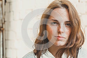 Outdoor beauty. Portrait of smiling young and happy woman with freckles.