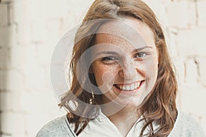 Outdoor beauty. Portrait of smiling young and happy woman with freckles.