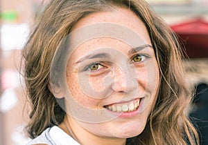 Outdoor beauty. Portrait of smiling young and happy woman with freckles.