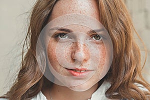 Outdoor beauty. Portrait of smiling young and happy woman with freckles.