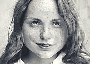 Outdoor beauty. Portrait of smiling young and happy woman with freckles. Black and white.