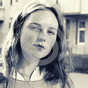 Outdoor beauty. Portrait of smiling young and happy woman with freckles. Black and white.