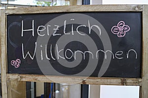 Outdoor blackboard with the German text `Herzlich willkommen`