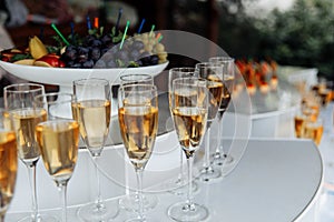Outdoor buffet with glasses of champagne and wine.