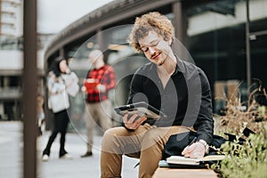 Entrepreneurs meeting outdoors, young man using tablet with colleagues in background