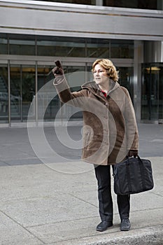 Outdoor business woman hailing a taxi cab