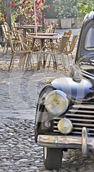 Outdoor cafe scene with old car