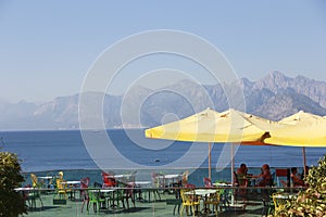 Outdoor cafe with tables and chairs on the outdoor terrace overlooking the blue sea