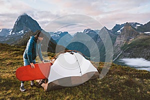 Outdoor camping gear: Man with red sleeping pad and tent in mountains of Norway. Travel hiking adventure healthy lifestyle