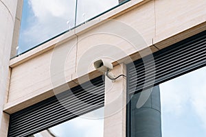 An outdoor CCTV camera on the wall of an office business center. The concept of protecting businesses from hooliganism photo