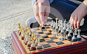 Outdoor chess game. Wooden chessboard with silver and gold pieces