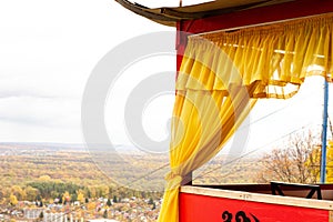 outdoor chinese style wooden gazebo with yellow curtains, beautiful restaurant with a gazebo and views of the mountains