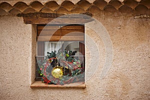 Outdoor christmas decoration. Golden ball and garlands on a window