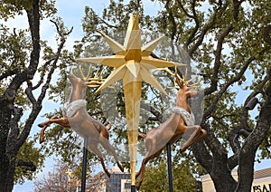 Outdoor Christmas decorations with two flying reindeer and a gold star suspended in midair in Dallas, Texas