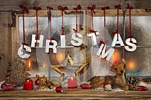 Outdoor christmas window decoration with red candles, deer and t