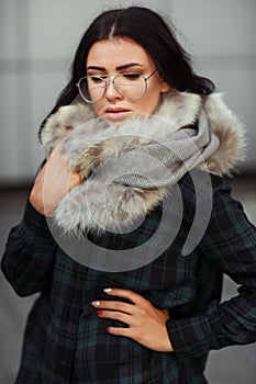 Outdoor close up fashion portrait of young beautiful confident woman wearing trendy shirt, white scarf and sunglasses Beautiful