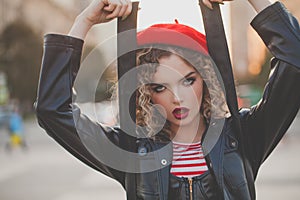 Outdoor close up fashion portrait of young beautiful fashionable woman in red beret