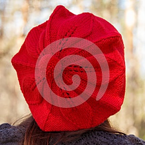 Outdoor close up portrait of young beautiful happy smiling girl wearing french style red knitted beret