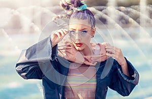 Outdoor close up portrait of a young lady with crazy look. Fashionable girl posing on street. Model girl wearing stylish