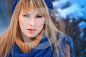 Outdoor closeup portrait of young pretty blonde girl walking in the cold winter weather in the park. Sensual long-haired