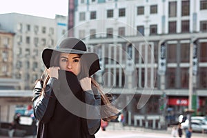 Outdoor closeup shot of woman in fashionable black coat and stylish hat.Female fashion concept