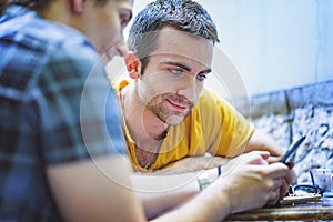 Outdoor coffee shop, two male friends