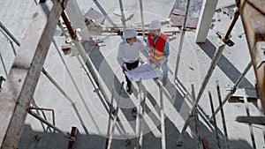 On outdoor construction sites, Asian engineers and architects Consulting and planning the construction of the building to be compl