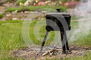 Outdoor cooking, smoky cast iron pot.