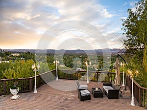 Outdoor deck with tables and chairs, offering a picturesque mountain view in Encino, CA