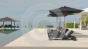 Outdoor deck, terrace with sun bed, black umbrellas and gray towels near the swimming pool, next to the beach front