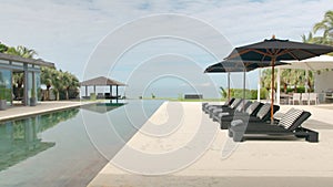 Outdoor deck, terrace with sun bed, black umbrellas and gray towels near the swimming pool, next to the beach front