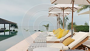 Outdoor deck, terrace with sun bed, umbrellas and towels near the swimming pool, next to the beach front