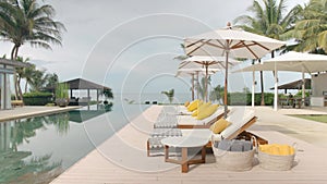 Outdoor deck, terrace with sun bed, umbrellas and yellow towels near the swimming pool, next to the beach front